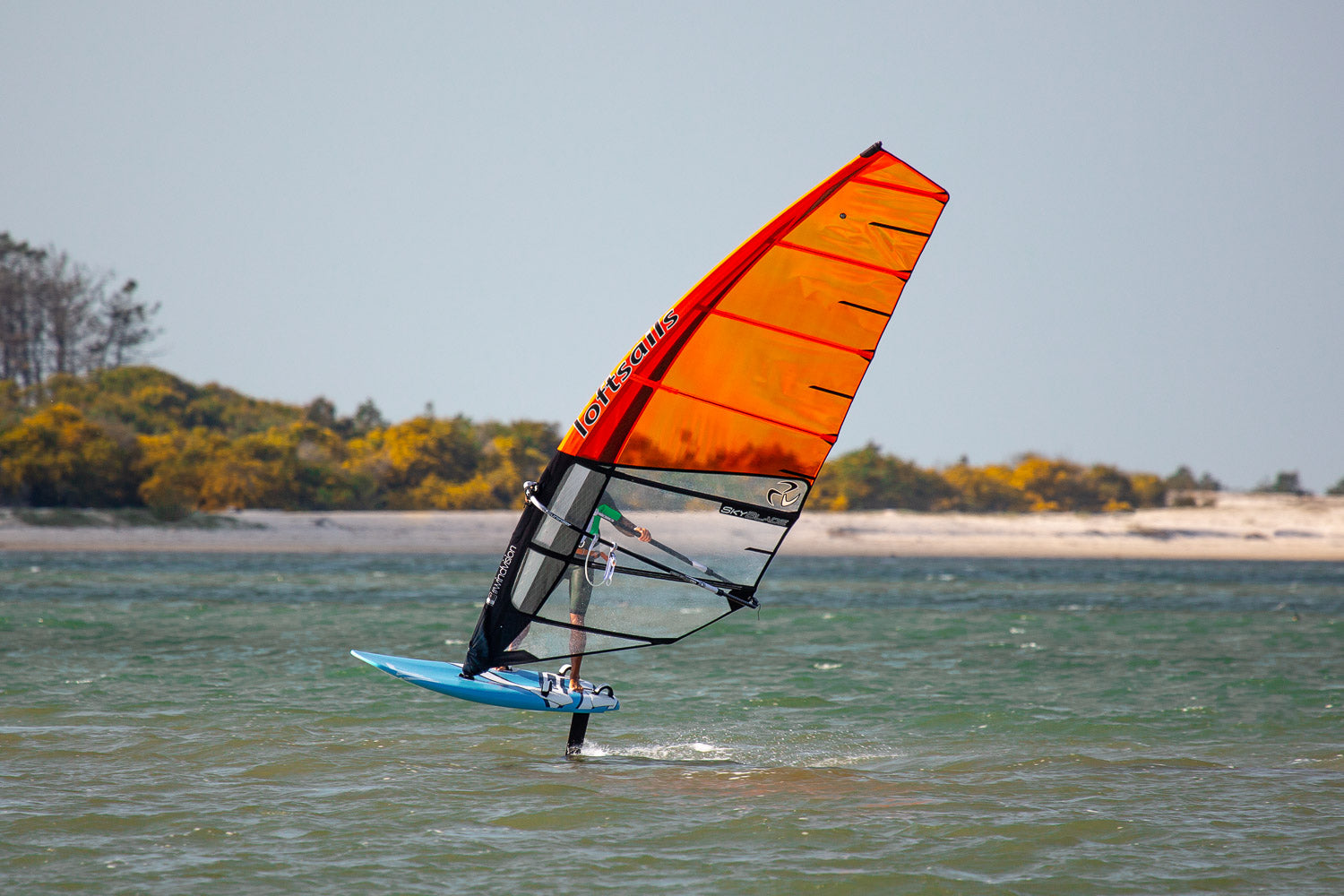 Person windsurfing with an orange sail and blue board.