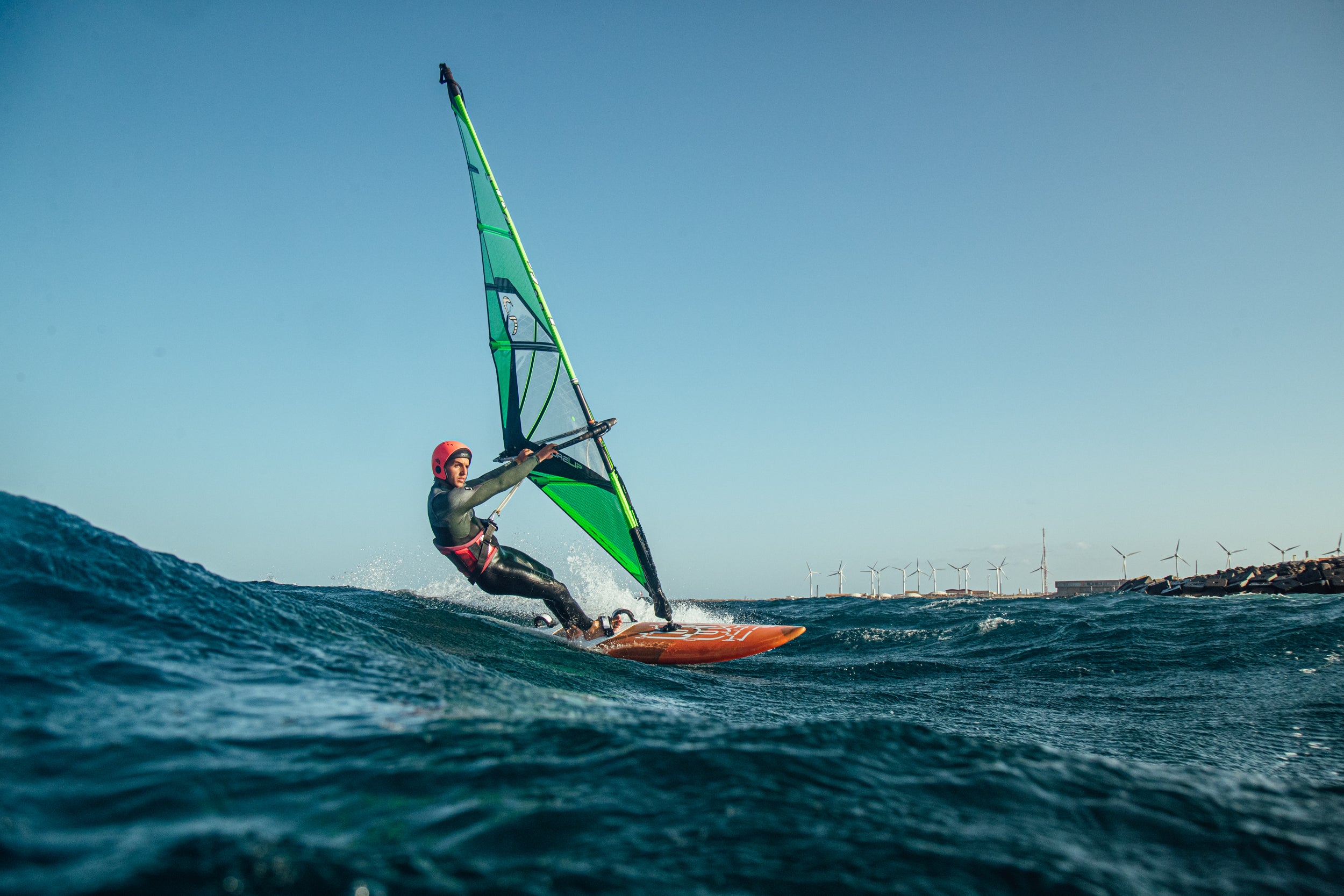 Person windsurfing on a blue ocean with a clear sky