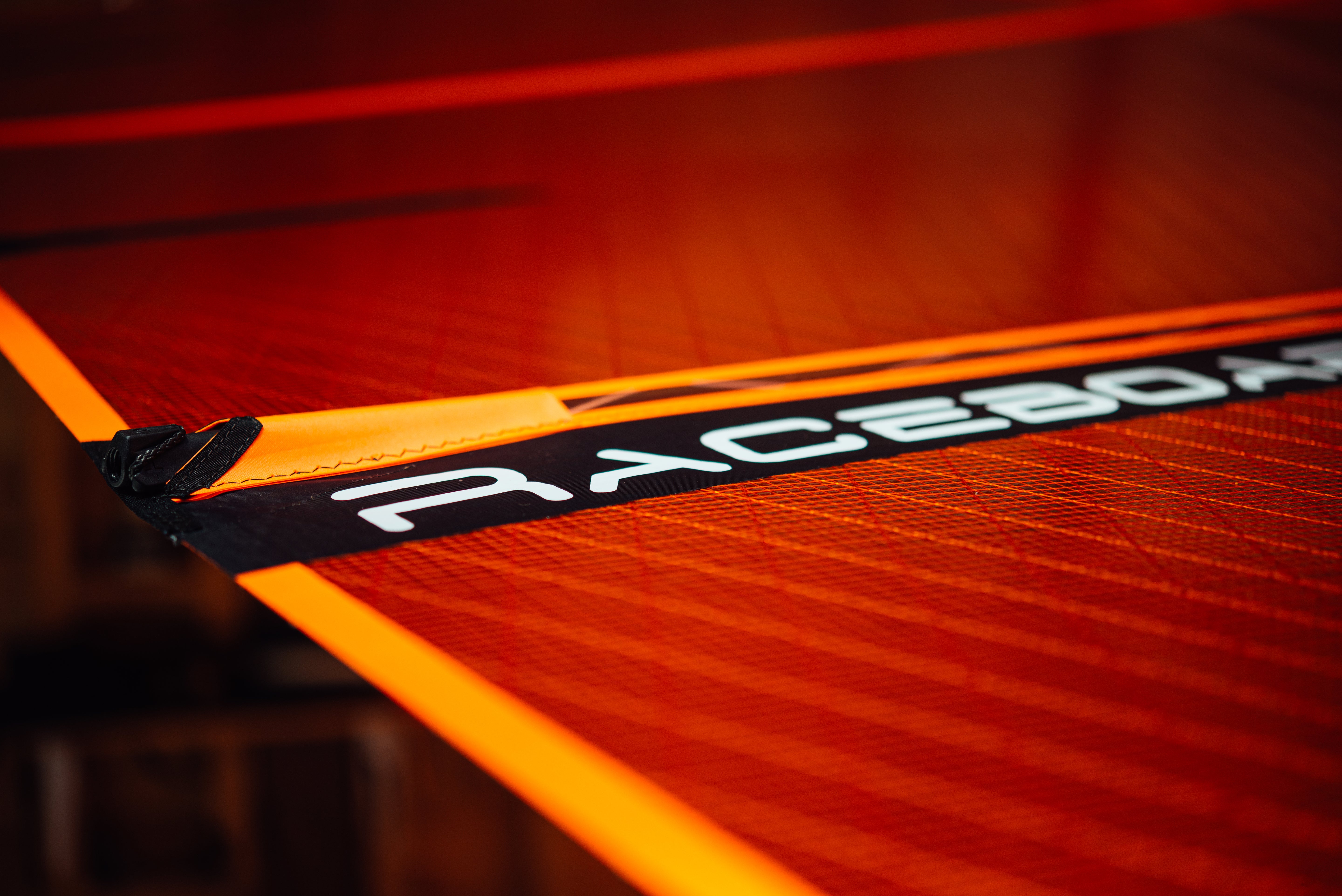 Close-up of a red and black sail with 'Raceboard' branding.