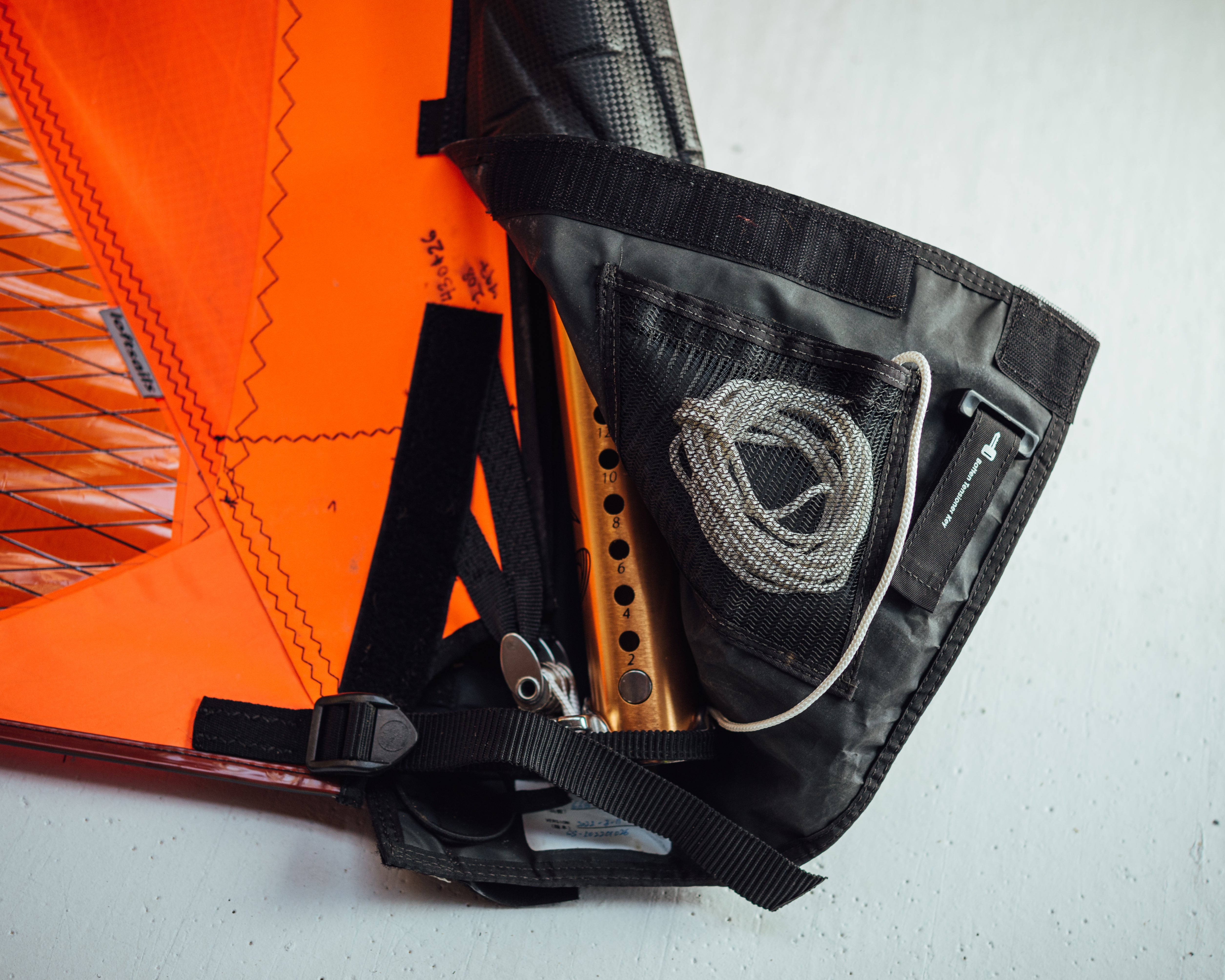 Close-up of a black bag with rope and orange fabric on a white background